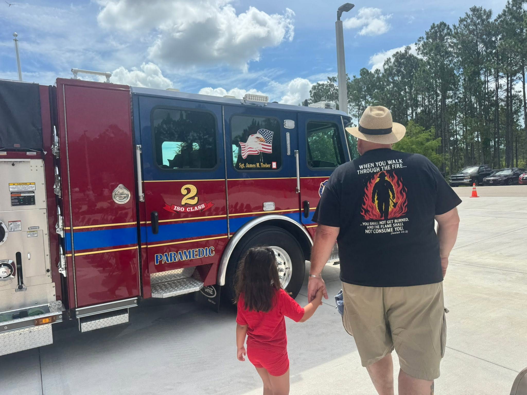 Joseph walking his granddaughter up to a fire engine