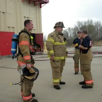 Firefighters staged with SCBA packs during a live training drill