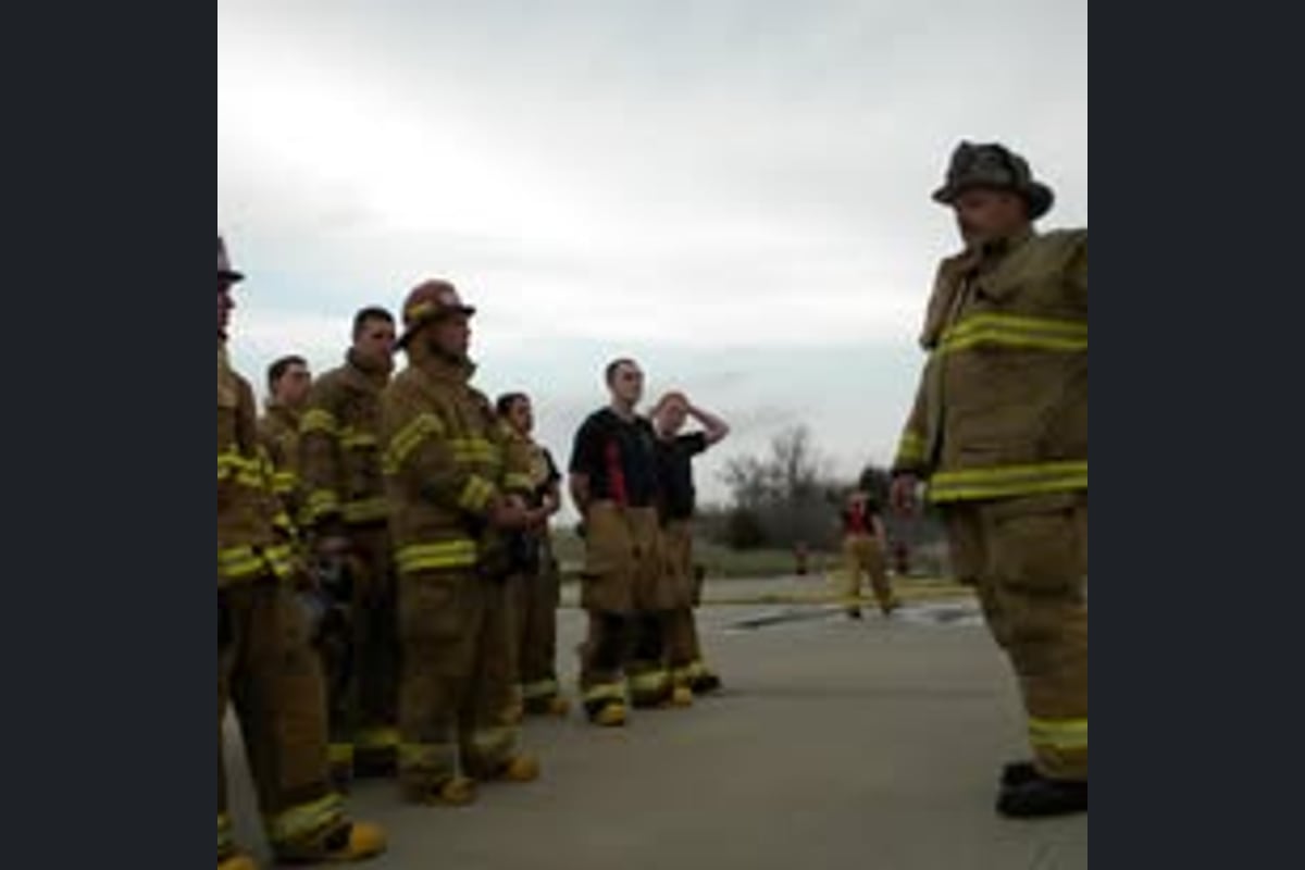 Joseph instructing a line of firefighters on the training ground
